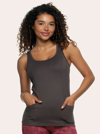 A woman wearing a gray Athletic Tank Top with no visible patterns, posing with hands in shirt pockets.