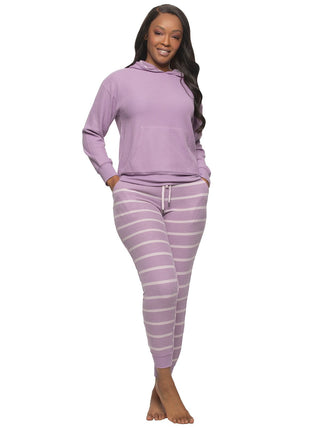 Woman wearing a purple hoodie and purple pants with white stripes on a white background