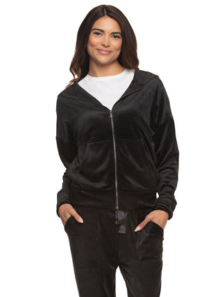 Woman wearing a black velvet zip-up hoodie partially zipped with white crew new tshirt underneath and matching pants on a white background